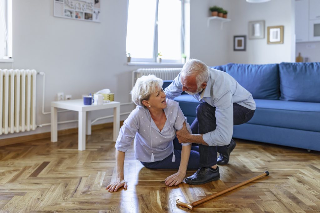husband helps wife who fell to the floor, senior fall reduction is key to limit injuries.