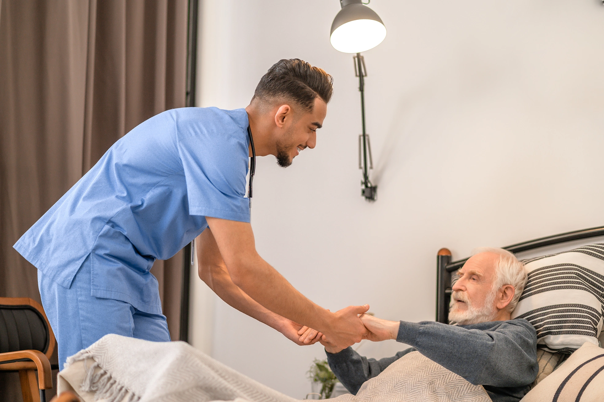 Imperial Beach, CA Male Caretaker helps elderly male get out of bed