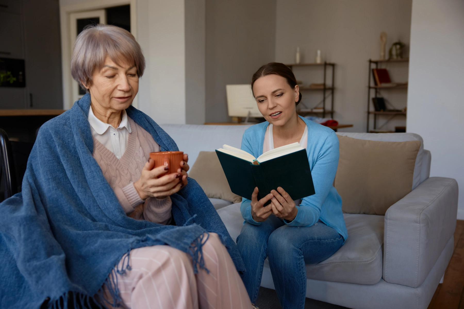 La Presa CA Home Care female caretaker reads to elderly female client