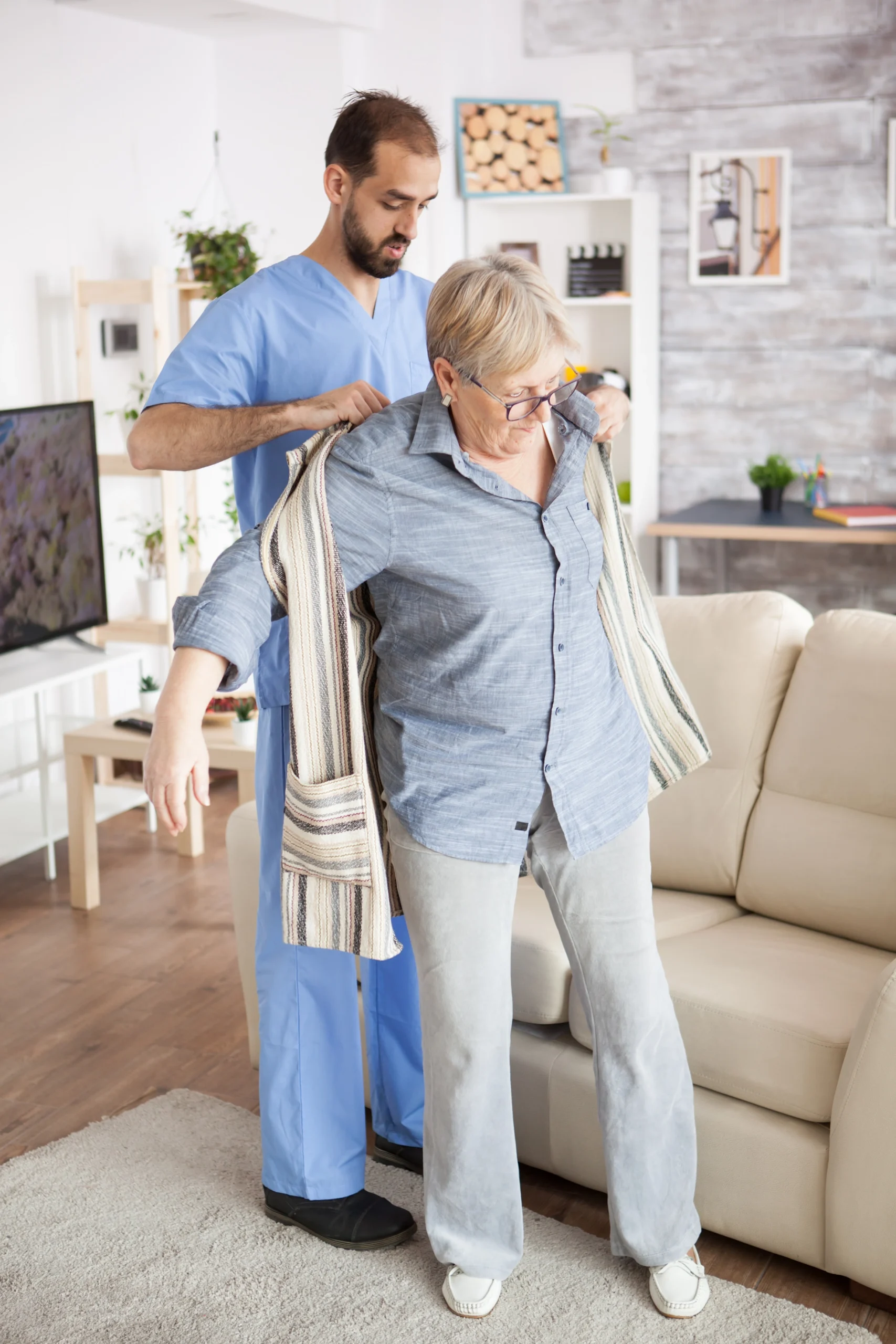 Senior Care National City CA male nurse helps elder woman with jacket