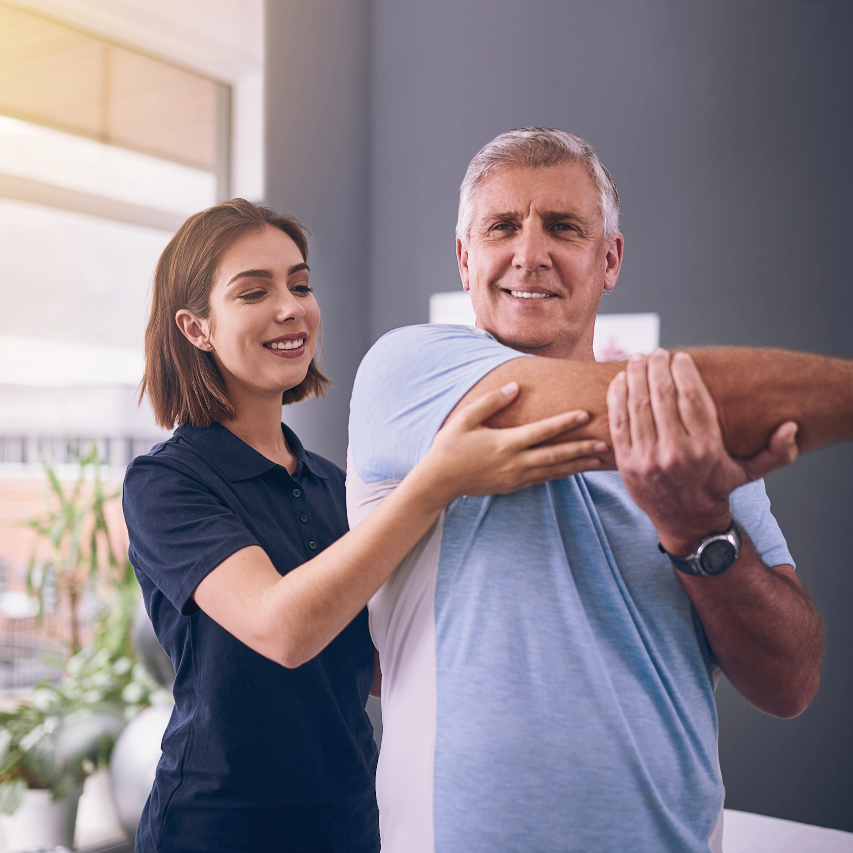 female caregiver helps male with his arm pain